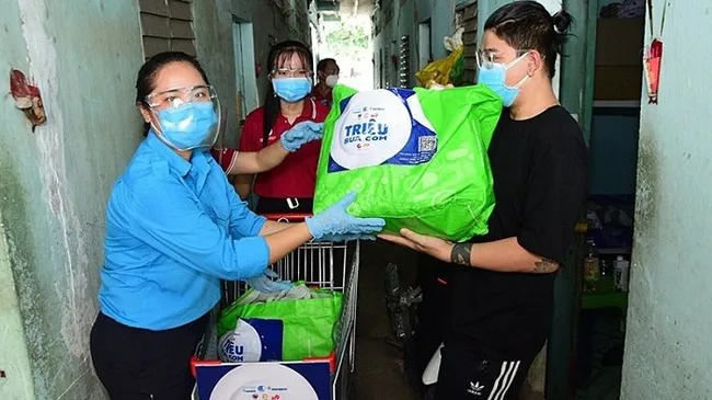 Members of the Vietnam Youth Federation present rice and food to needy people in Ho Chi Minh City.