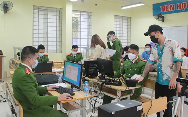 Hoang Mai district police cooperate with Mai Dong ward police to carry out procedures for issuing chip-based citizen identification cards at a vaccination point.