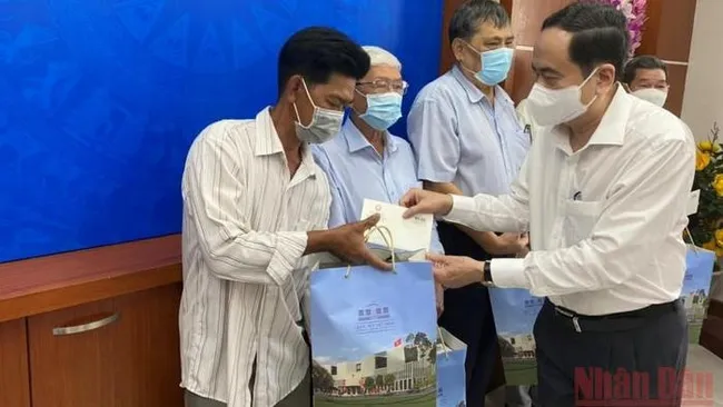 NA Vice Chairman Tran Thanh Man presents gifts to policy beneficiaries in Long Xuyen city. (Photo: NDO)