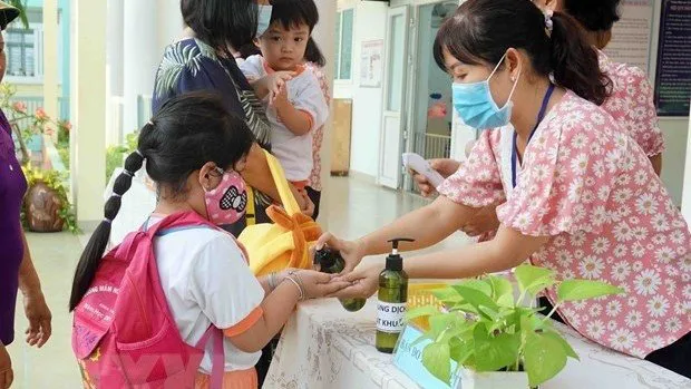 Kids wash their hands before entering the classroom. (Photo: VNA)