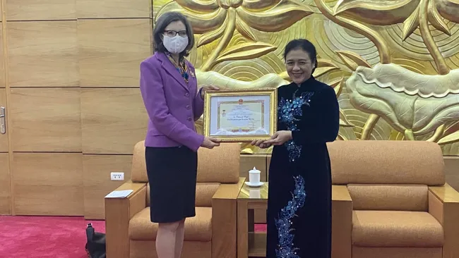 VUFO President Nguyen Phuong Nga presents the insignia to the Canadian Ambassador. (Photo: VUFO)