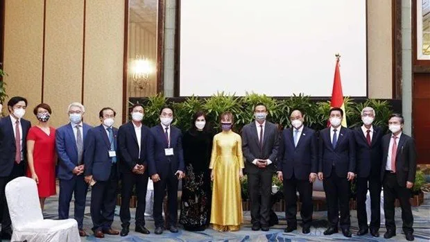 Participants in the meeting between President Nguyen Xuan Phuc (fourth from right) and Grab President Ming Maa (fifth from right) in Singapore on February 25 (Photo: VNA)