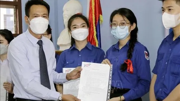 Tran Dai Thang, First Secretary of the Vietnamese Embassy in Laos, (first, on the left) presents scholarships of Ton Duc Thang University to students of Nguyen Du Lao-Vietnamese Bilingual School. (Photo: VNA)