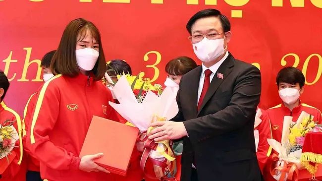 National Assembly Chairman Vuong Dinh Hue present gifts and flowers to female football players. (Photo: VNA)