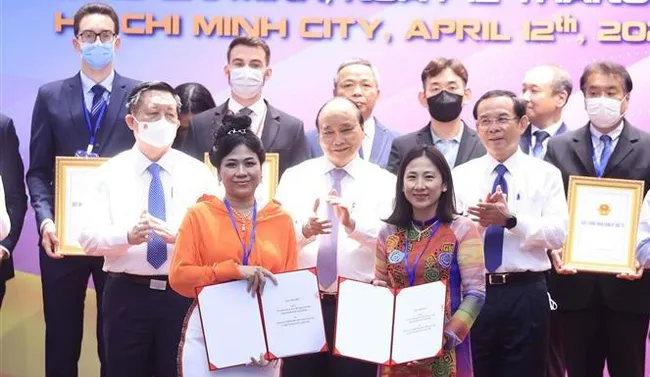 President Nguyen Xuan Phuc and delegates witness the signing of memoranda of understanding on investing in Cu Chi and Hoc Mon. (Photo: VNA)
