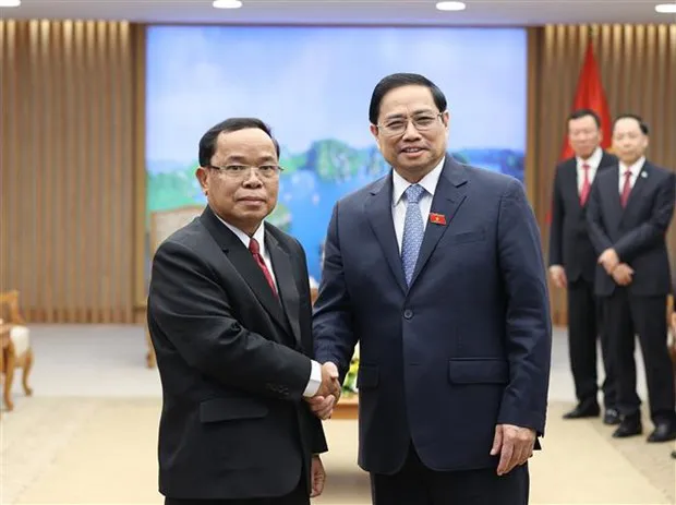 Prime Minister Pham Minh Chinh (R) receives President of the Lao State Inspection Authority Khamphan Phommaphat. (Photo: VNA)