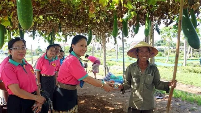 Representatives of the Lao Women's Union present the champa flower symbol of Laos to a resident of the Tra Que vegetable farming village in Hoi An city, Quang Nam province, during a visit in early July. (Photo: VNA)