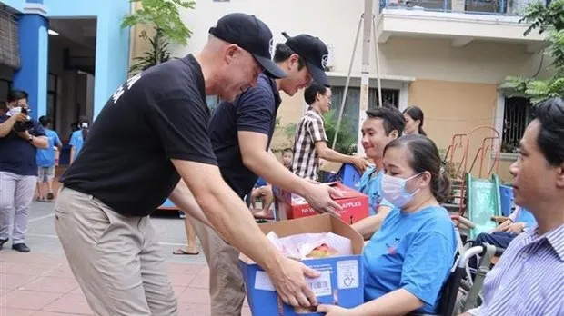 New Zealand Consul General Joe Nelson presents fruits to disadvantaged people in Maison Chance (Photo: VNA)