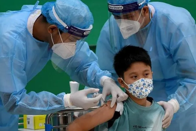 A child receives the COVID-19 vaccination (Photo: NDO)