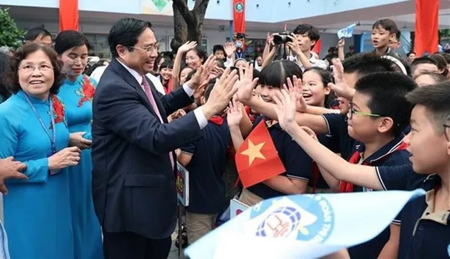 Students of Doan Thi Diem primary school welcome Prime Minister Pham Minh Chinh. (Photo: VNA)
