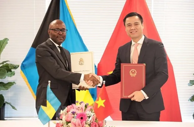 Ambassador Dang Hoang Giang (R), Permanent Representative of Vietnam to the UN, and his Bahamian counterpart Stan Oduma Smith exchange the signed joint communiqué on the establishment of diplomatic relations on January 6. (Photo: VNA)