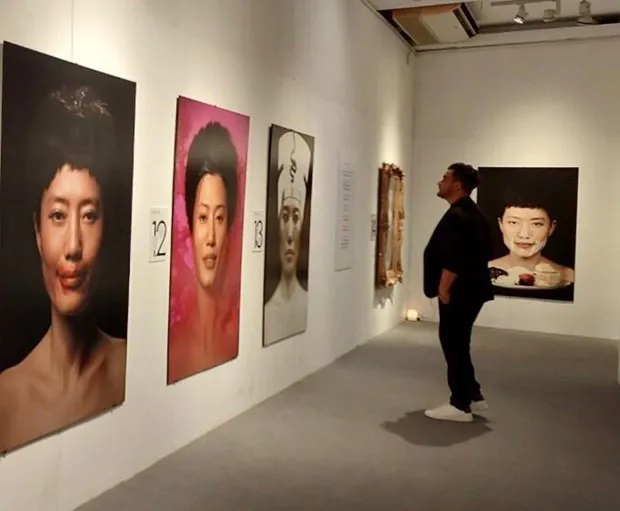 A visitor looks at photos by Spanish artist Salvador Perez Arroyo. (Photo: Vietnam Plus )
