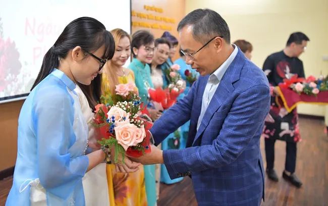 Vietnamese Ambassador to Thailand Phan Chi Thanh presets flowers to female participants at the event (Photo: NDO)