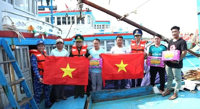 National flags presented to local fishermen. (Photo: qdnd.vn)