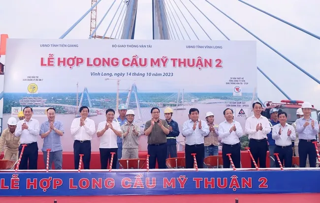 PM Pham Minh Chinh (front, centre) and officials at the ceremony marking the joining of the last sections of My Thuan 2 Bridge on October 14. (Photo: VNA)