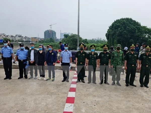 Three Chinese nationals are returned to China on June 15 after illegally entering Vietnam on June 9. (Photo: VNA)