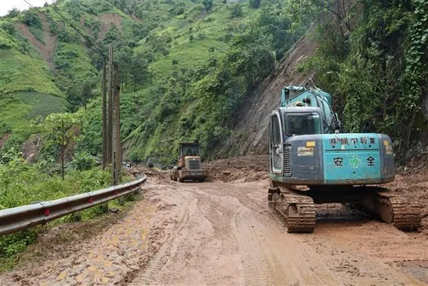 Excavators clear a landslide-hit road linking Khao Mang and Ho Bon communes of Mu Cang Chai district, Yen Bai province. (Photo: VNA)