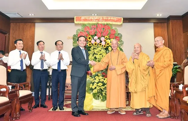 Deputy Prime Minister Tran Luu Quang presents flowers to Most Venerable Thich Tri Quang, Supreme Patriarch of the VBS Patronage Council (Photo: VNA)