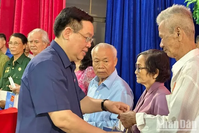 Chairman of the National Assembly Vuong Dinh Hue presents gifts to policy beneficiaries in Bac Lieu. (Photo: VNA)