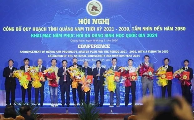 Leaders of Quang Nam province present investment policy approval decisions to businesses at the conference. (Photo: baoquangnam.vn)