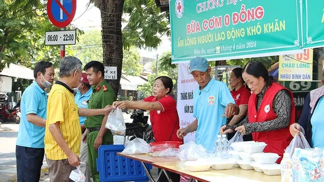 Members of the Red Cross Society deliver free meals to poor workers in Hoa An Ward, Cam Le District, Da Nang City. (Photo: NDO)