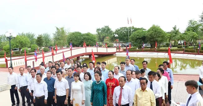 Vietnamese in Laos offer incense and flowers to President Ho Chi Minh. (Photo: VNA)