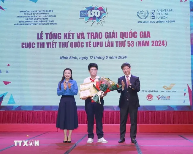 Nguyen Do Quang Minh (centre), a 9th grader in the central city of Da Nang, recieves the first prize at the awarding ceremony in Ninh Binh province. (Photo: VNA)