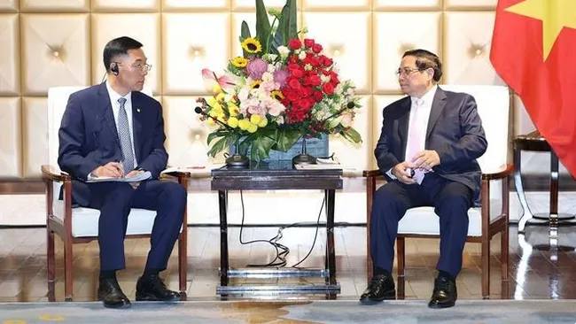 Vietnamese Prime Minister Pham Minh Chinh (right) and Chairman of the Dalian Locomotive and Rolling Stock Co. Ltd. (CRRC) Sun Rongkun at their meeting in Dalian city in China’s Liaoning province on June 24. (Photo: VNA)