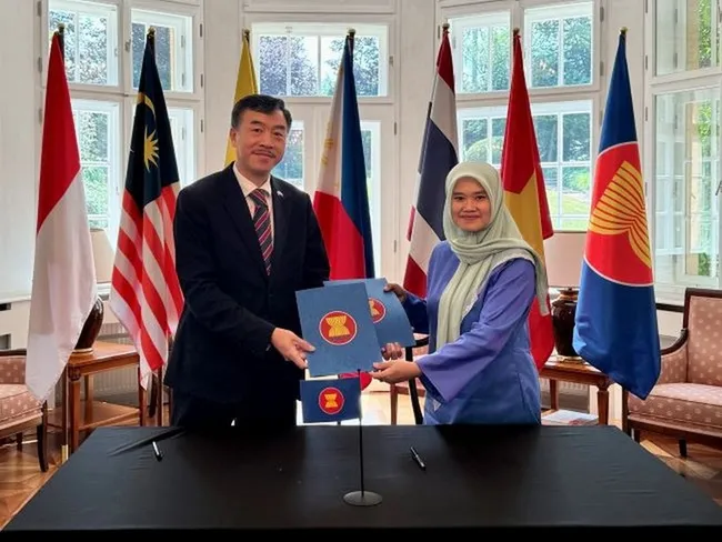 Vietnamese Ambassador to the Czech Republic Duong Hoai Nam receives the rotary chair of the ASEAN Committee in Prague from Malaysian Ambassador Suzilah Mohd Sidek. (Photo: VNA)