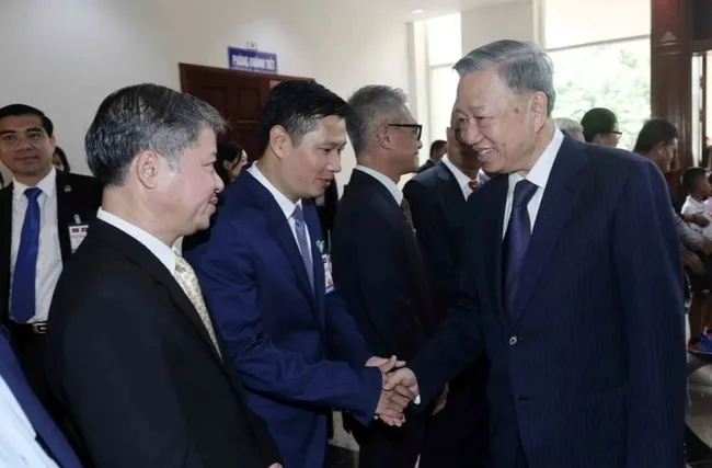 State President To Lam (R) meets Vietnamese Embassy staff and representatives of the Vietnamese community in Laos (Photo: VNA)