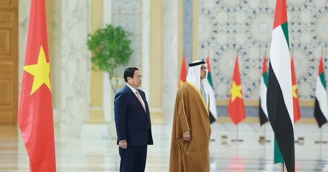 Prime Minister Pham Minh Chinh (L) and Vice President of the United Arab Emirates (UAE) Sheikh Mansour bin Zayed Al Nahyan at the official welcome ceremony for the Vietnamese leader. (Photo: VNA)