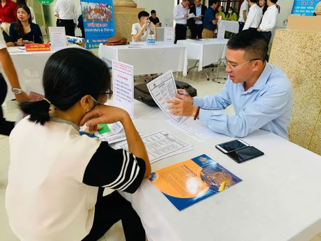 A business representative gives information to a job seeker. (Illustrative photo: VNA)