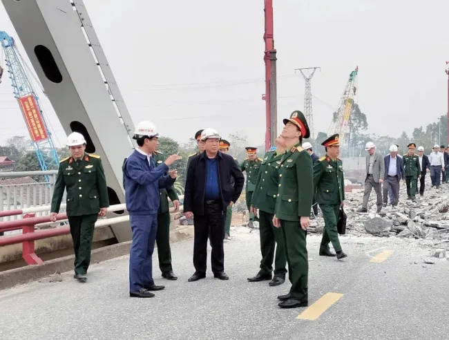 Minister of Transport Tran Hong Minh (central, in black) inspects the work at the construction site of the new Phong Chau bridge in the northern province of Phu Tho. (Photo: VNA)