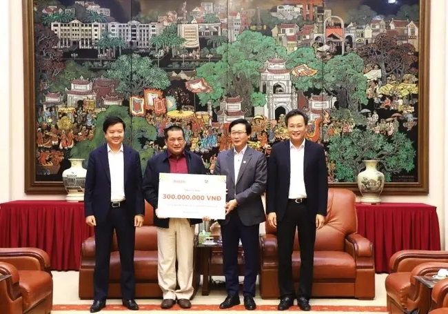 Representatives of Nhan Dan Newspaper and Vietnam Reading and Learning Culture JSC present 300 million VND to leaders of Hung Yen province to care for policy beneficiaries in the locality
