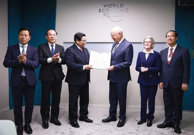 Prime Minister Pham Minh Chinh presents the honorary doctorate to Professor Klaus Schwab, Founder and Executive Chairman of the World Economic Forum. (Photo: VGP)