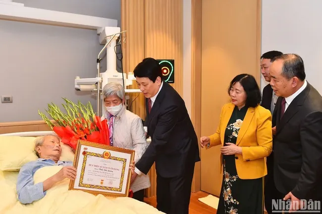 President Luong Cuong presents the badge to former President Tran Duc Luong.