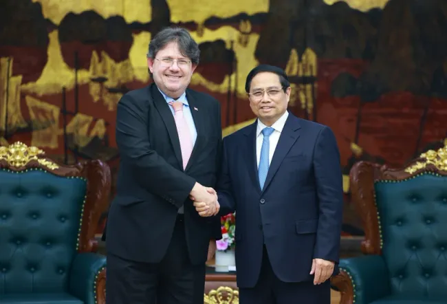 Prime Minister Pham Minh Chinh (R) welcomes Austrian Ambassador to Vietnam Philipp Agathonos in Hanoi on March 26 evening. (Photo: VNA)