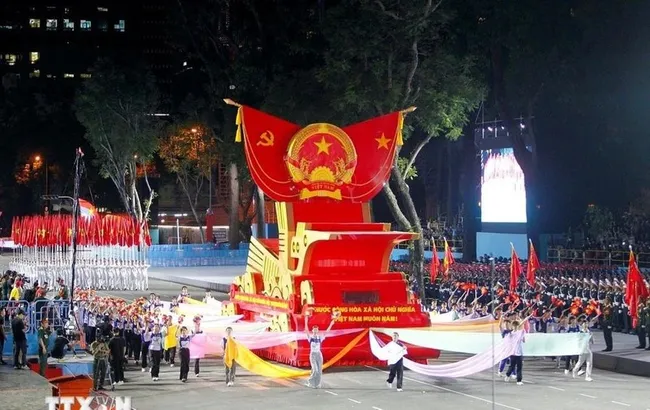 A parade float bearing the national emblem of the Socialist Republic of Vietnam takes part in the second full rehearsal for the upcoming military parade and mass procession celebrating national reunification. (Photo: VNA)