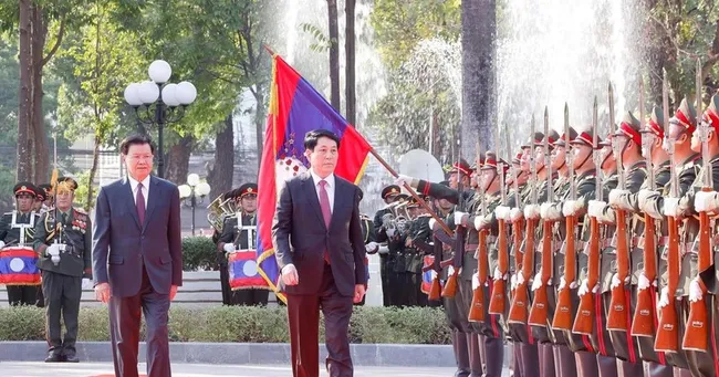 State President Luong Cuong (R) and General Secretary of the Lao People's Revolutionary Party (LPRP) Central Committee and President of Laos Thongloun Sisoulith review the guard of honour at the welcome ceremony on April 24 afternoon. (Photo: VNA)