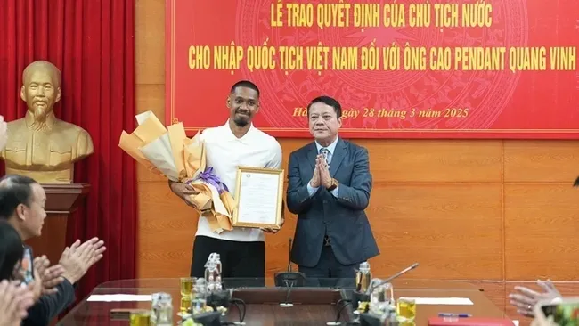 Representative of Hanoi Department of Justice presents the Vietnamese nationality certificate to football player Cao Pendant Quang Vinh.