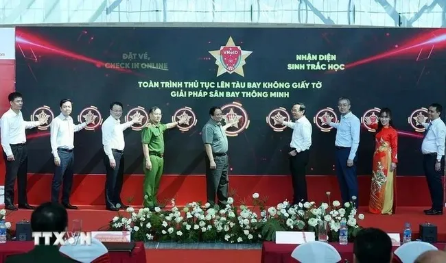 PM Pham Minh Chinh (fifth from left) and officials at the ceremony for the pilot rollout of the electronic identification, authentication, and biometric boarding solution at Terminal 3 of Tan Son Nhat International Airport on April 19 (Photo: VNA)