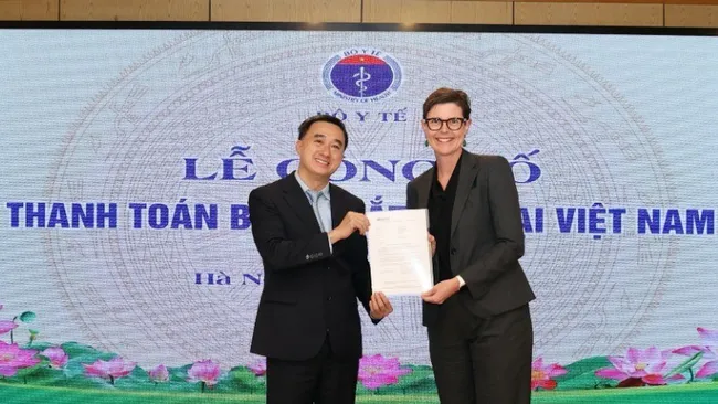Dr Angela Pratt, WHO Representative in Vietnam presents the certificate of trachoma elimination to Deputy Minister of Health Tran Van Thuan. (Photo: NDO)