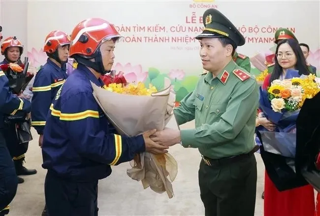 MPS Deputy Minister, Lieutenant General Le Van Tuyen, presents flowers to congratulate officers and soldiers of the MPS’ search and rescue team on their successful return from Myanmar. (Photo: VNA)