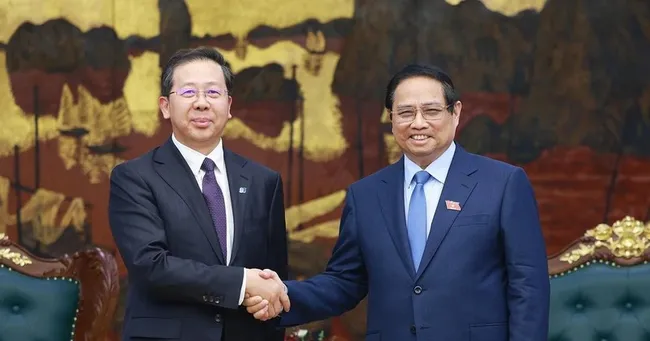 Prime Minister Pham Minh Chinh (R) receives Peng Gangping, Chairman of China Huadian Engineering Co., Ltd. (Photo: VNA)