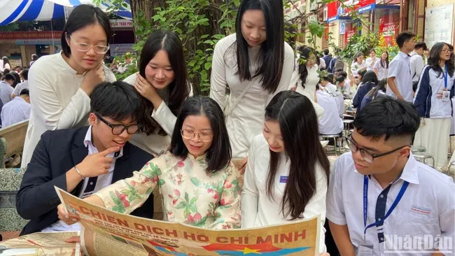 Teachers and students of Tran Phu High School explore the special publication on the Ho Chi Minh Campaign issued by Nhan DanNewspaper. (Photo: NDO)