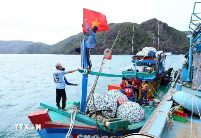 Fishermen prepare their vessels before setting out to sea, ensuring compliance with fisheries regulations. (Photo: VNA)