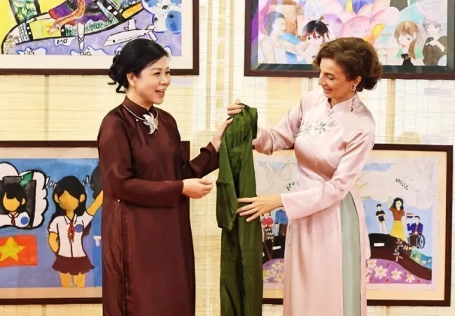 Madam Ngo Phuong Ly (L) presents a traditional Vietnamese Ao dai (long dress) to UNESCO Director-General Audrey Azoulay. (Photo: VNA)