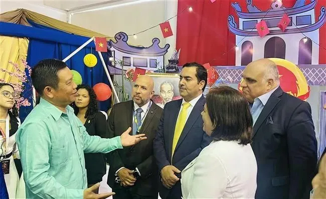 Vietnamese Ambassador to Venezuela Vu Trung My (left) and representatives of Santa María University at the “Viet Nam – Land and People” space during the 2025 International Student Festival. (Photo: VNA)