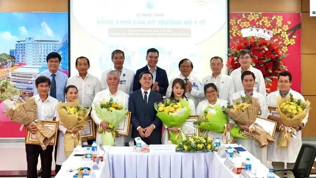 Deputy Minister of Health Tran Van Thuan presents flowers and certificates of merit to the team who performed the fetal intervention for the Singaporean mother. (Photo: NDO)