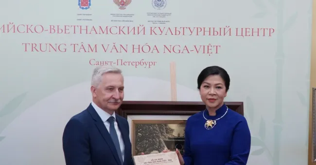 Madame Ngo Phuong Ly (R), wife of Party General Secretary To Lam, presents the book series 
